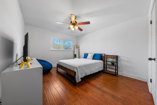 Bedroom with ceiling fan, wood-style flooring and spacious closet | Image 19
