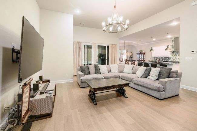Living area with light wood-style flooring, recessed lighting, a chandelier, and french doors | Image 4