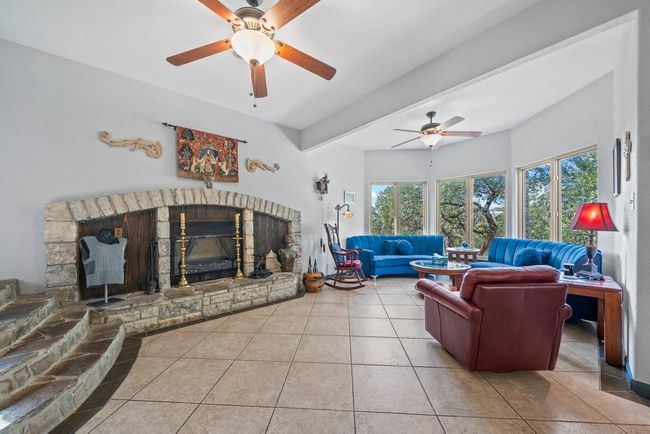 Tiled living room with a glass covered fireplace | Image 5