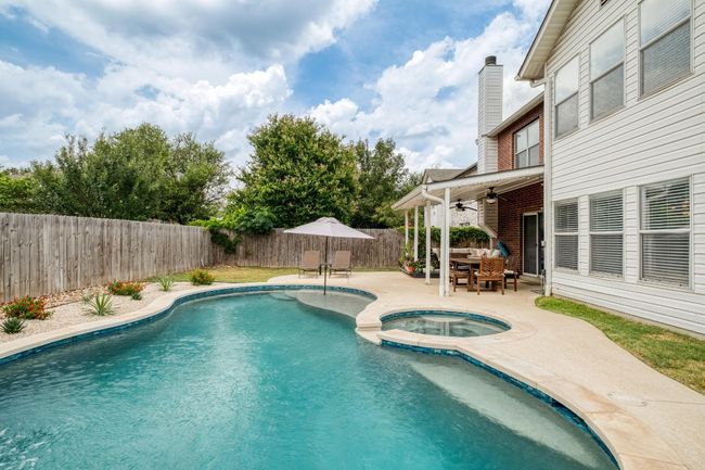 View of pool featuring a ceiling fan, a patio, a fenced backyard, outdoor dining space, and a pool with connected hot tub | Image 34