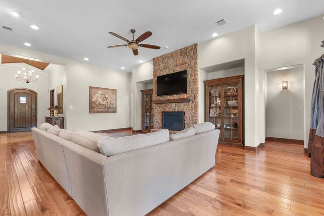 Living room featuring wood-style flooring, a fireplace, a ceiling fan, and recessed lighting | Image 13