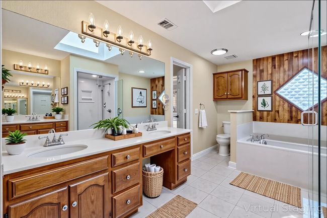 Full Primary bathroom featuring double vanity, a garden tub, tile patterned floors, toilet, and baseboards | Image 19