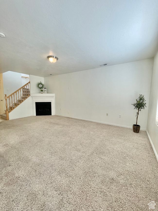 Unfurnished living room with carpet flooring and a textured ceiling | Image 6