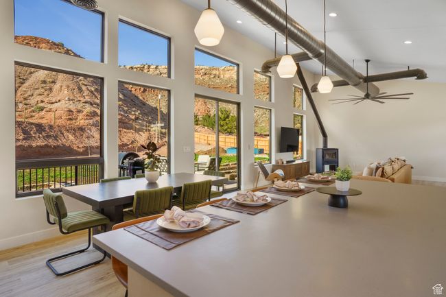 Dining area featuring healthy amount of natural light, a towering ceiling, light wood-type flooring, recessed lighting, and baseboards | Image 13