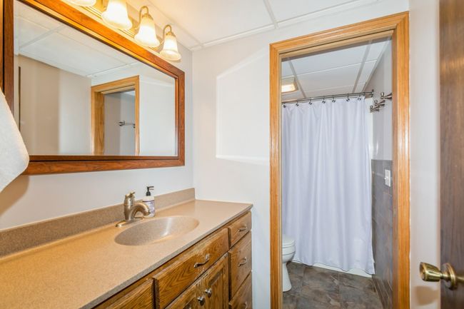Full bathroom in the lower level has a pocket door to the stool and shower to make your mornings go smoother with separate areas to get ready! Heated tile flooring. | Image 44