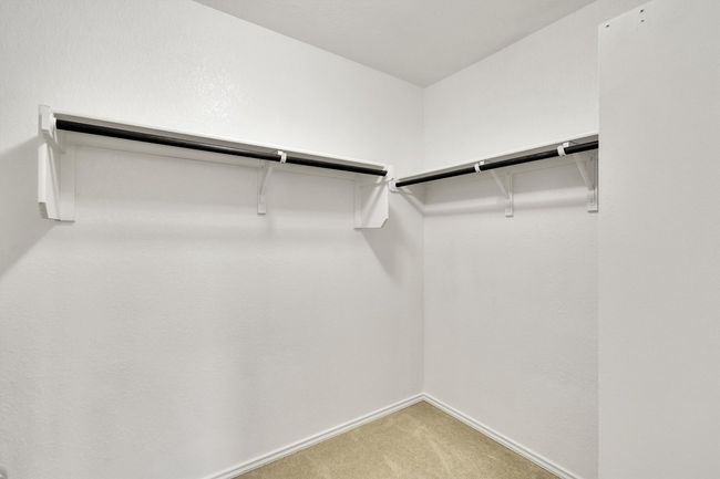 Spacious closet featuring light colored carpet | Image 27