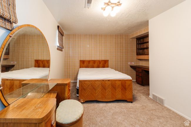 Carpeted bedroom featuring a textured ceiling | Image 24