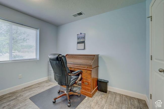 Home office with wood finished floors, visible vents, and baseboards | Image 22