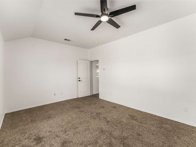 Empty room featuring carpet, a ceiling fan, and lofted ceiling | Image 29