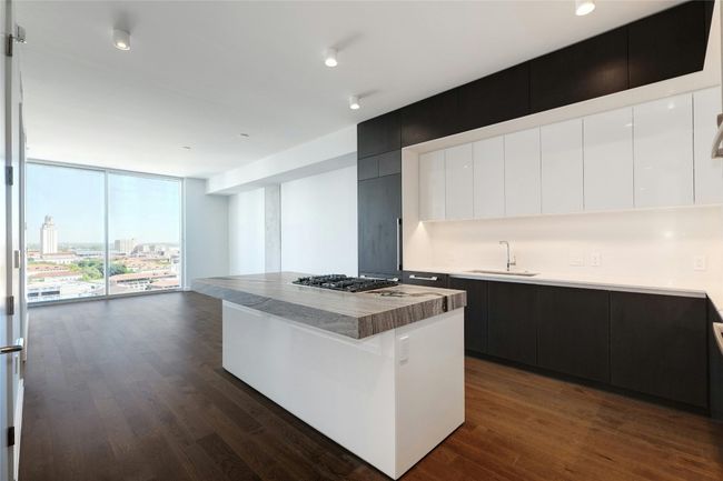 Kitchen featuring a sink, wood finished floors, a wall of windows, and modern cabinets | Image 5
