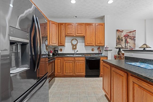 The kitchen has ample cabinets for storage. | Image 12