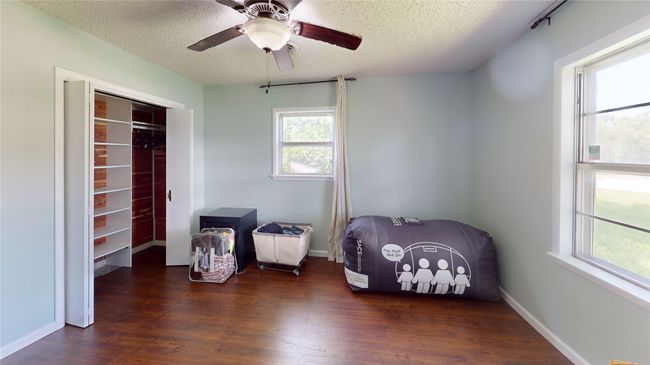 Bedroom with wood finished floors, a textured ceiling, a ceiling fan, and a closet | Image 21