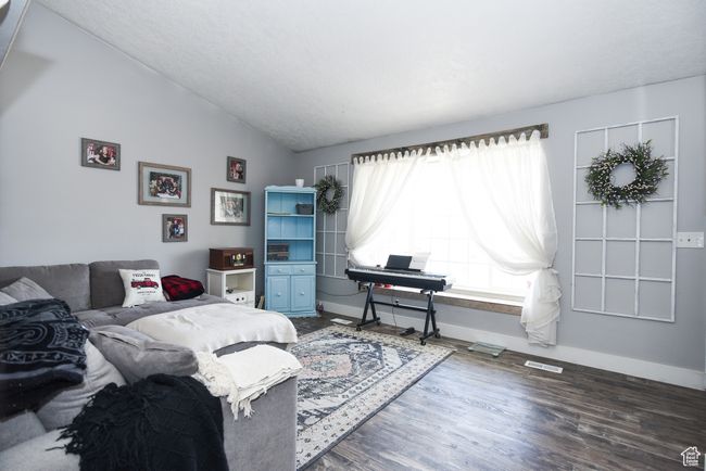 Bedroom featuring visible vents, wood finished floors, lofted ceiling, and baseboards | Image 10