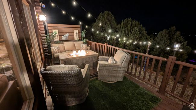 View of wooden balcony featuring a fire pit and a wooden deck | Image 4