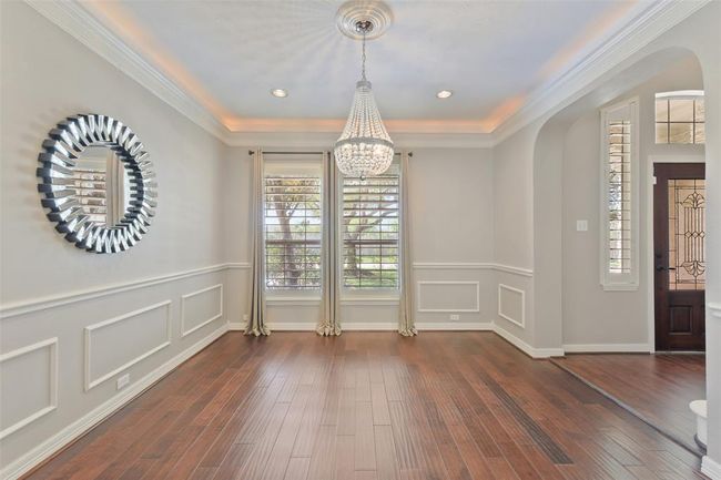 Formal dining room with Plantation shutters, rope lights, updated lighting and fresh paint. Love the crown and chair molding. | Image 11