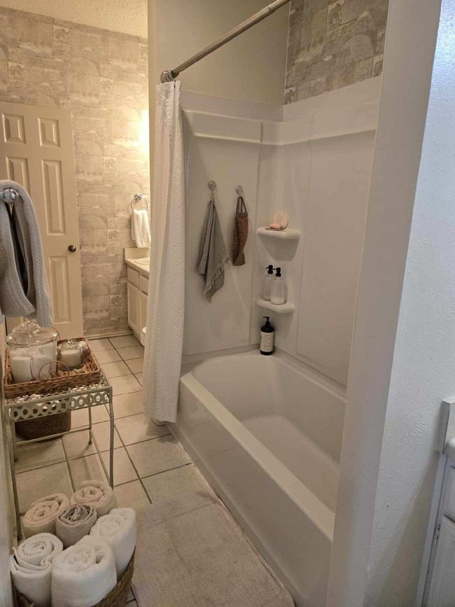 Full bath with shower / bath combo, tile patterned floors, and vanity | Image 5