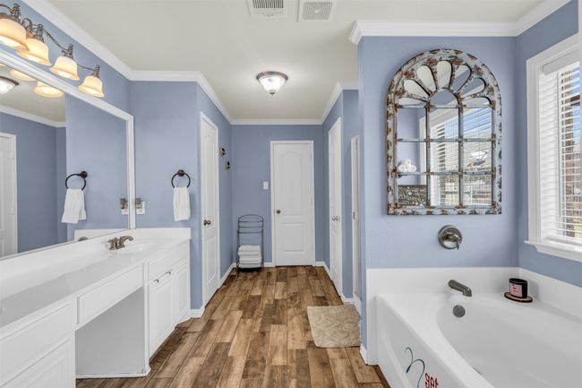 Bathroom with ornamental molding, vanity, hardwood / wood-style floors, and a tub | Image 10
