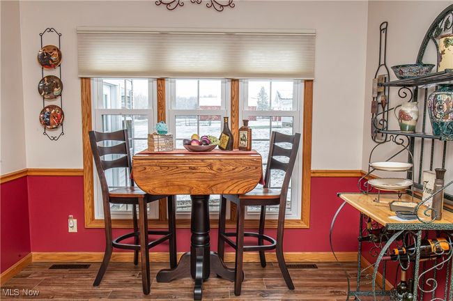 Dining area with baseboards, visible vents, wood finished floors, and a healthy amount of sunlight | Image 6