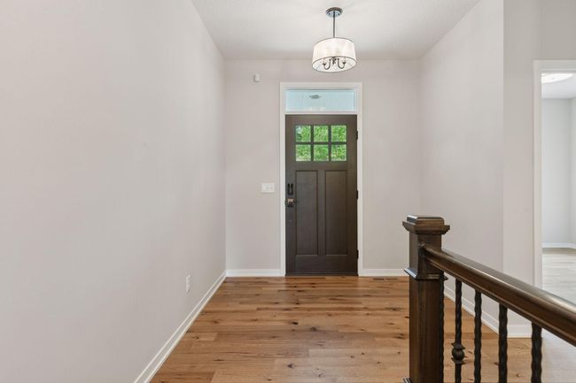 As you enter you will appreciate the light, bright finishes creating a beautiful blend of enameled cabinets and trim, gorgeous hardwood floors, all in pristine condition | Image 4