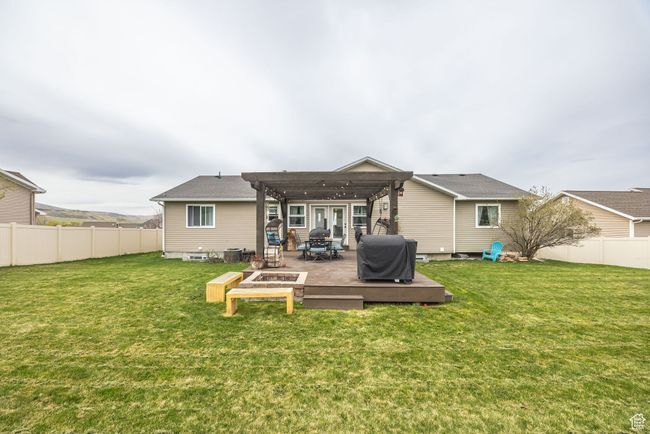 Back of house featuring a fenced backyard, a wooden deck, a pergola, and a yard | Image 35
