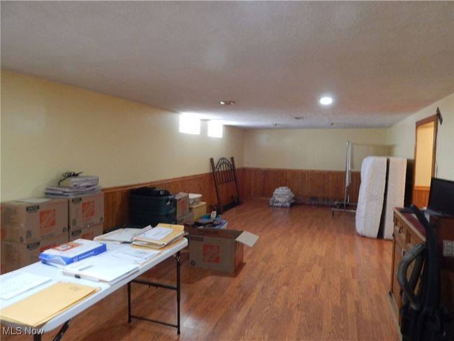 Extra spacious 37 x 12 Finished Recreation Room with wood-look flooring, and wainscot trimmed wooden walls. | Image 22