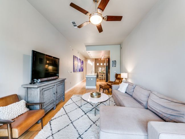 Living room featuring a ceiling fan, light wood finished floors, baseboards, and a chandelier | Image 12