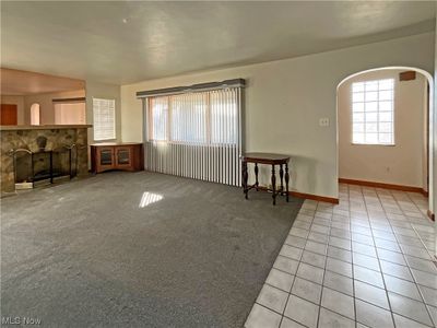 Unfurnished living room with a fireplace and light carpet | Image 2