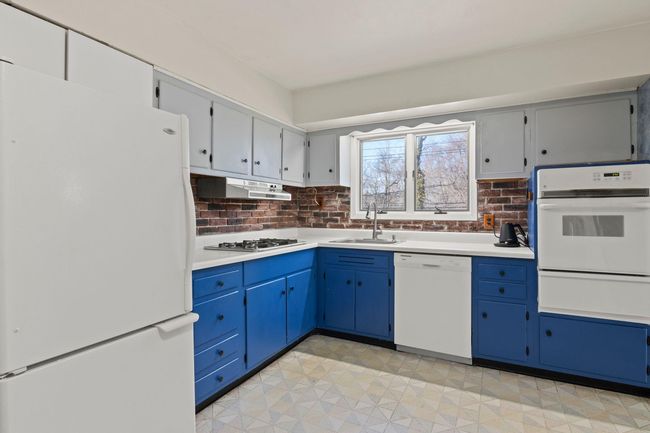 Kitchen with light countertops, white appliances | Image 10