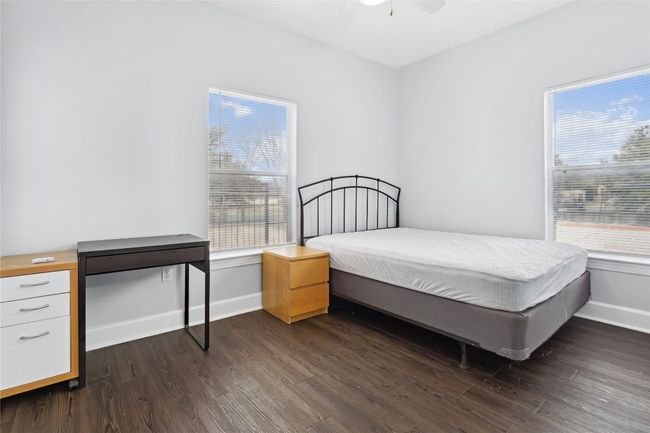 Bedroom with baseboards, dark wood-type flooring, and ceiling fan | Image 22