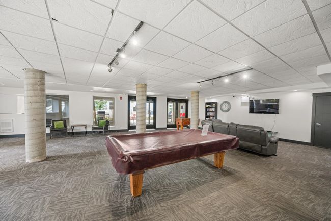 Rec room featuring rail lighting, decorative columns, and carpet floors | Image 35