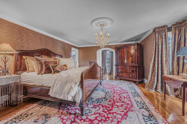 Bedroom with ornamental molding, hardwood / wood-style floors, and an inviting chandelier | Image 16