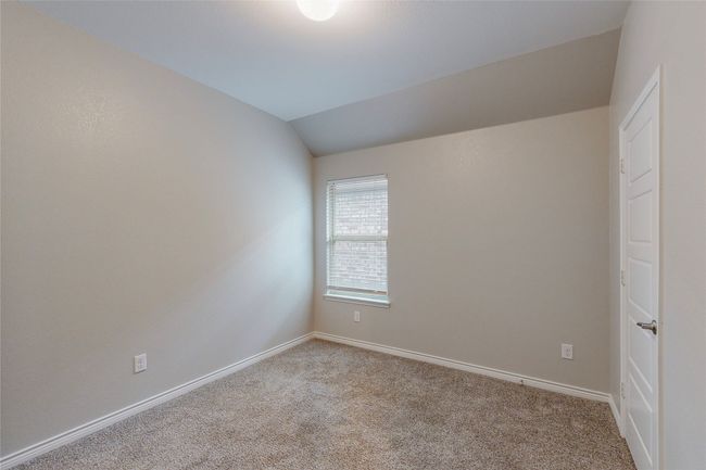 Carpeted empty room featuring lofted ceiling and baseboards | Image 31