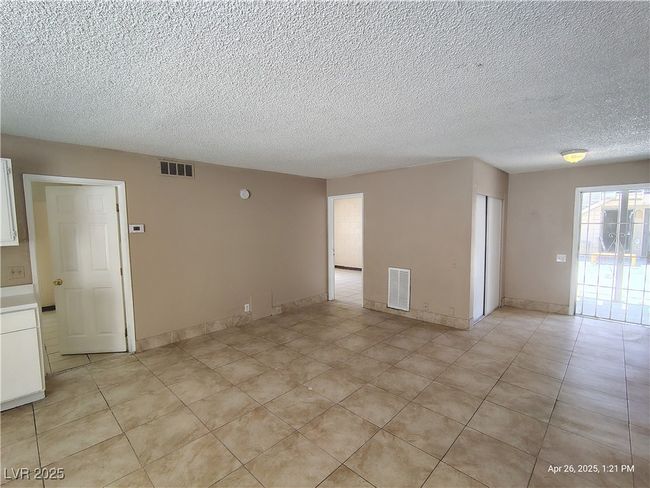 Empty room featuring a textured ceiling, visible vents, light tile patterned flooring, and baseboards | Image 6