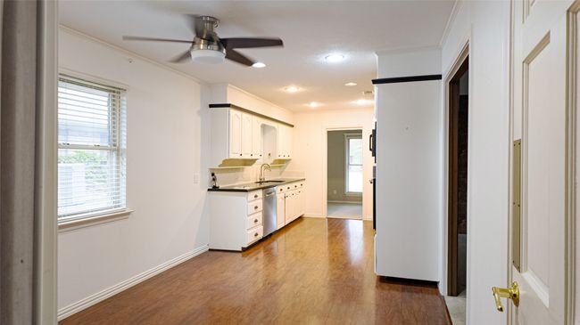 Kitchen featuring a ceiling fan, crown molding, dark wood-type flooring, dishwasher, and a sink | Image 15