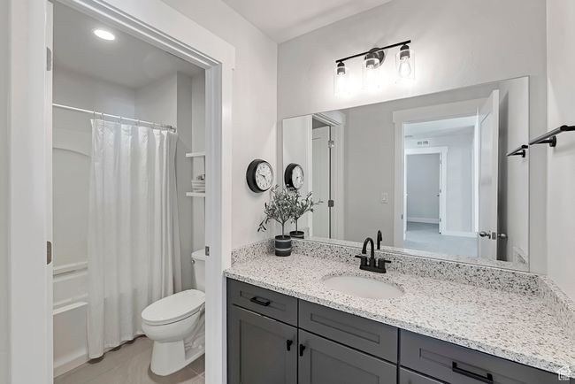 Bathroom featuring toilet, vanity, tile patterned flooring, and shower / bath combo with shower curtain | Image 18