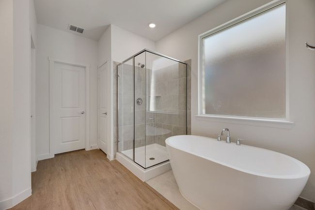 Bathroom with a freestanding bath, a stall shower, wood finished floors, and recessed lighting | Image 22
