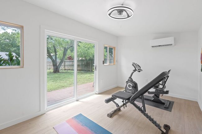 Workout area featuring a wall mounted AC and light wood finished floors | Image 29