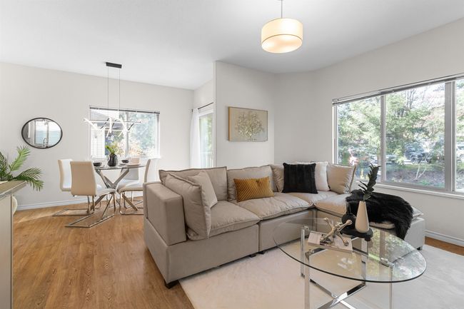 Living area with plenty of natural light, wood finished floors, and baseboards | Image 11