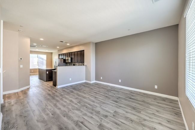 Unfurnished living room with light wood finished floors, baseboards, and visible vents | Image 4