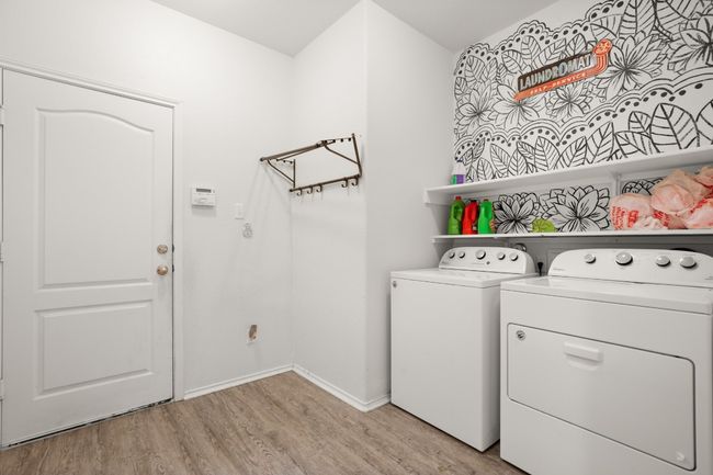 Washroom with washer and dryer, laundry area, baseboards, and light wood-type flooring | Image 8