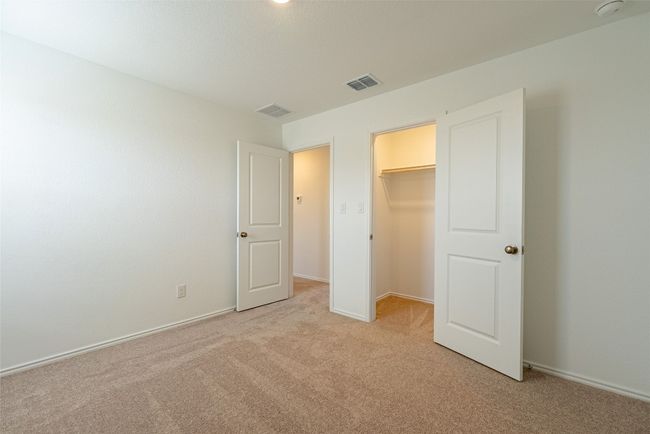 Unfurnished bedroom featuring light colored carpet, a spacious closet, a closet, and baseboards | Image 18