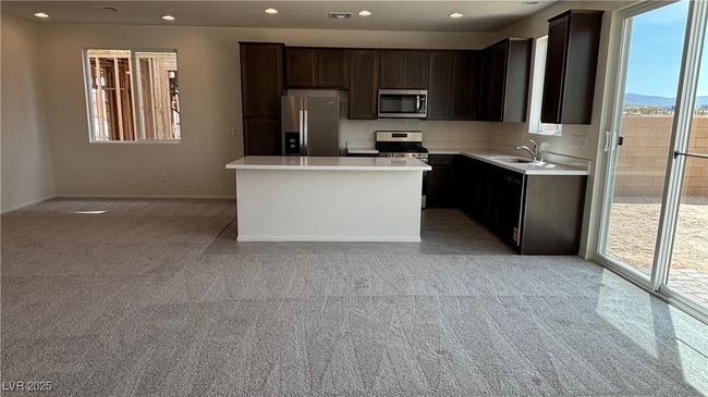 Kitchen with a sink, stainless steel appliances, visible vents, light carpet, and light countertops | Image 4