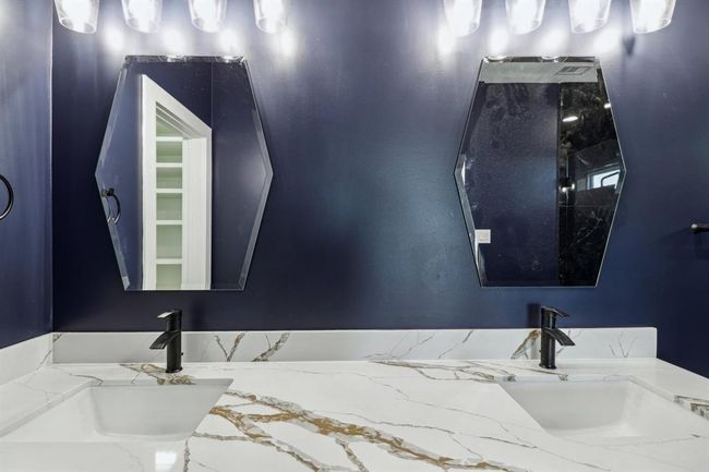 Quartz countertops with gorgeous mirrors enhancing the overall elegance and functionality of the bathroom | Image 17