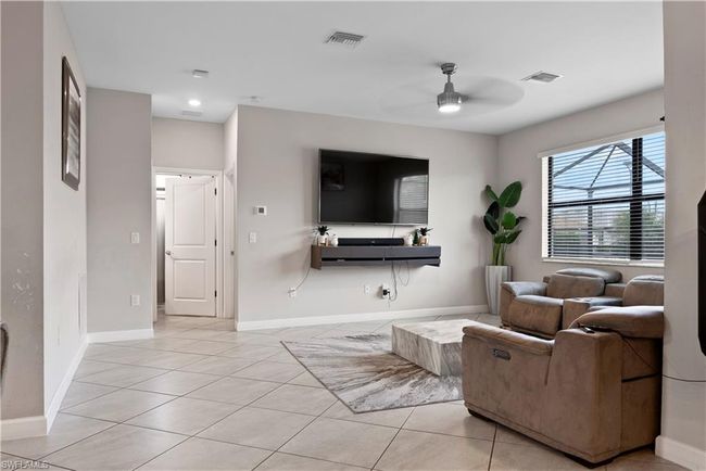 Living room featuring light tile patterned floors, baseboards, visible vents, and a ceiling fan | Image 14