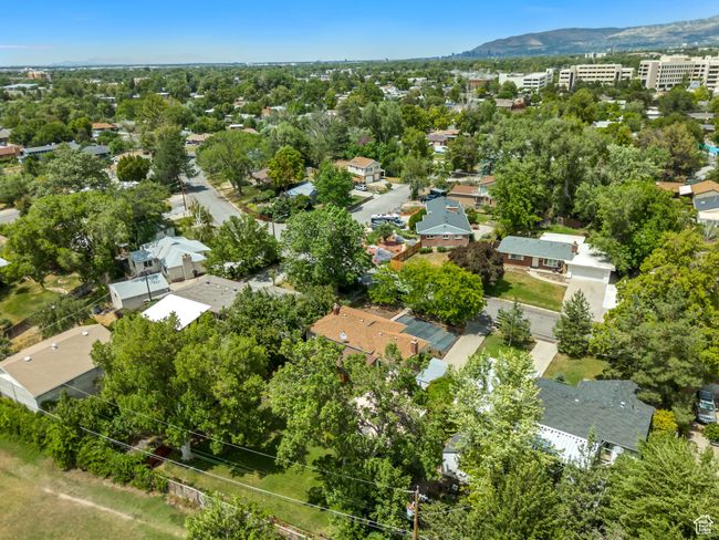 Aerial perspective of suburban area featuring a mountain backdrop and a tree filled landscape | Image 38