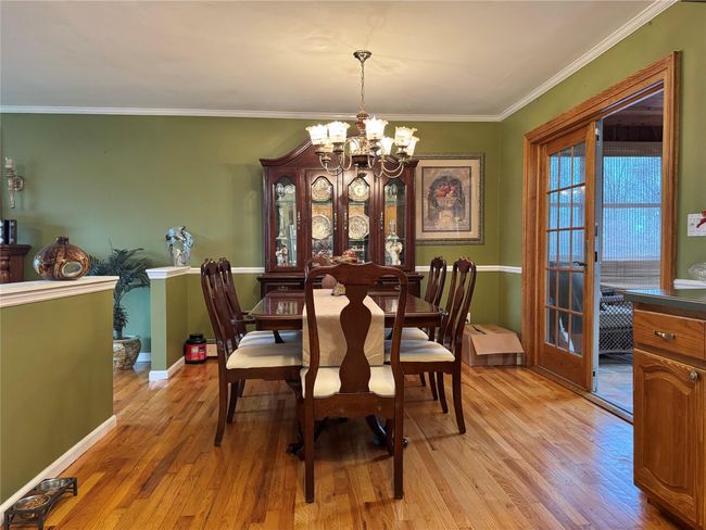 Dining space with a chandelier, light wood finished floors, baseboards, and ornamental molding | Image 10