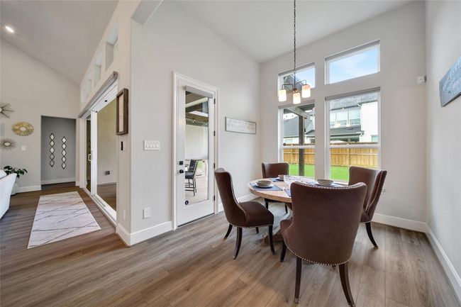 Bright and airy breakfast room just off the kitchen with backyard views through large windows. | Image 17