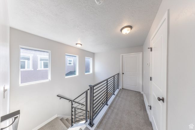 Corridor featuring an upstairs landing. Windows bring in natural, cheerful lighting to this area. | Image 21