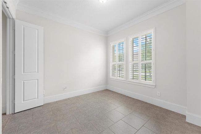 This bright room makes an ideal home office—easy-to-clean tile floors, plantation shutters to control glare, and a peaceful view of the front yard. Just add your desk and you’ve got a productive, light-filled workspace. | Image 10