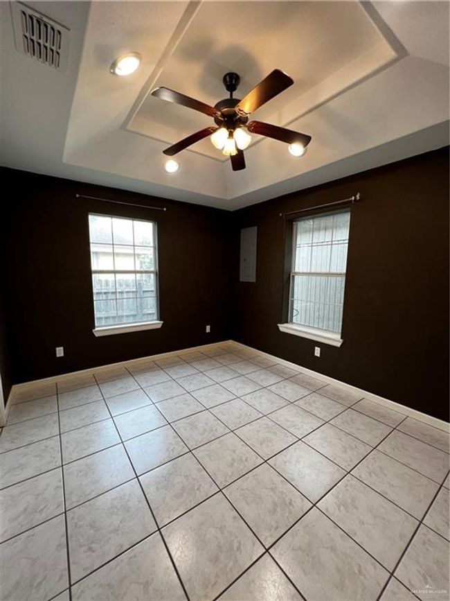 Spare room with a raised ceiling, light tile patterned flooring, and ceiling fan | Image 8